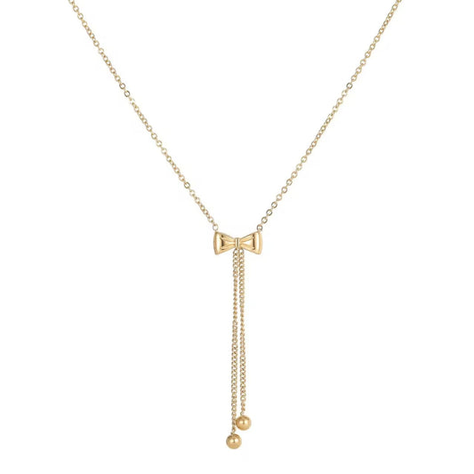 A gold-colored bow necklace with a chain link design and a small spherical pendant at the end.