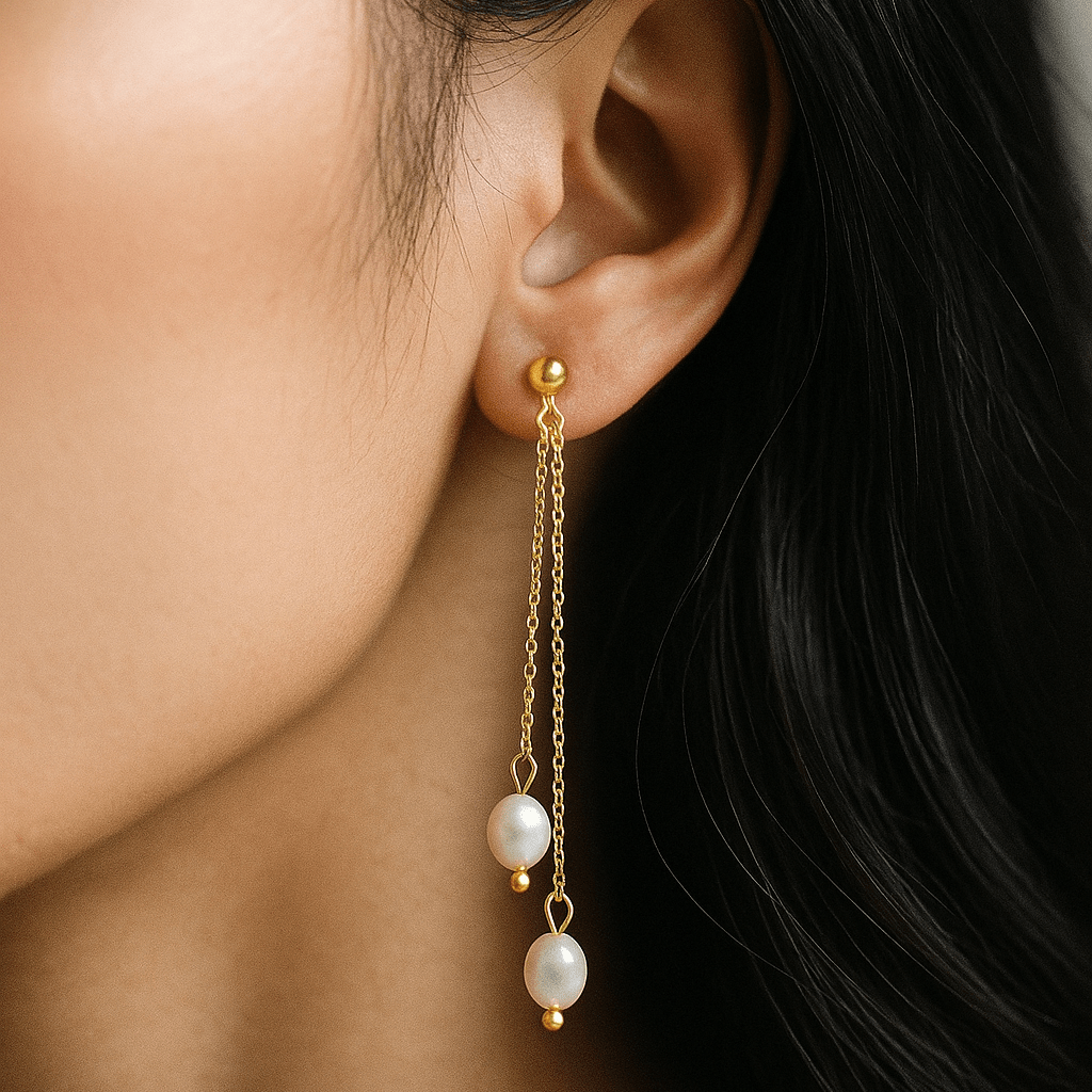 Gold earring with pearl drops worn by a person
