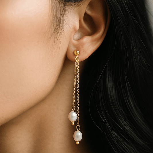 Gold earring with pearl drops worn by a person