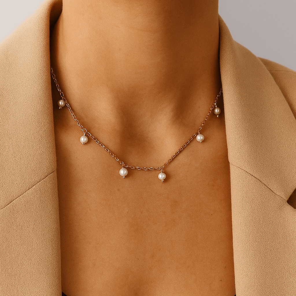 Necklace with pearls worn by a person in a beige coat