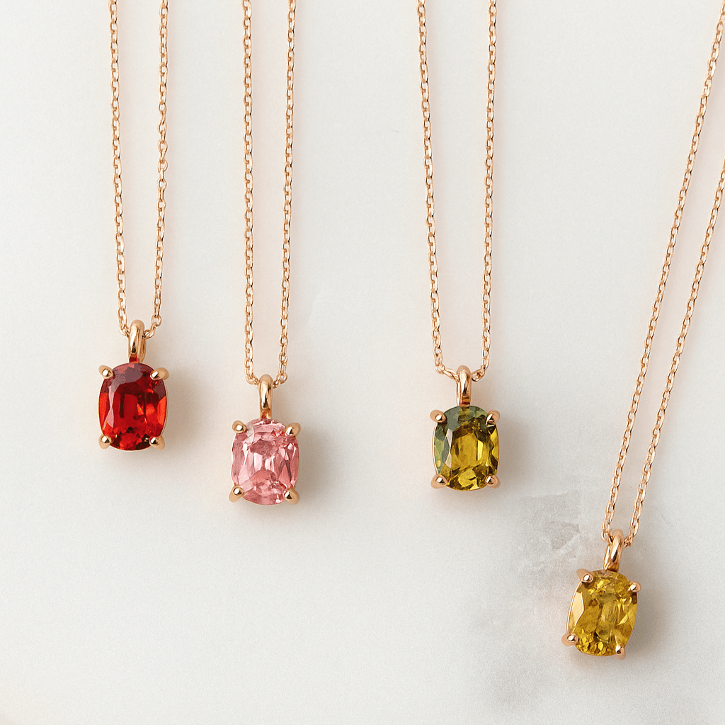Four gold necklaces with colored gemstones on a white background