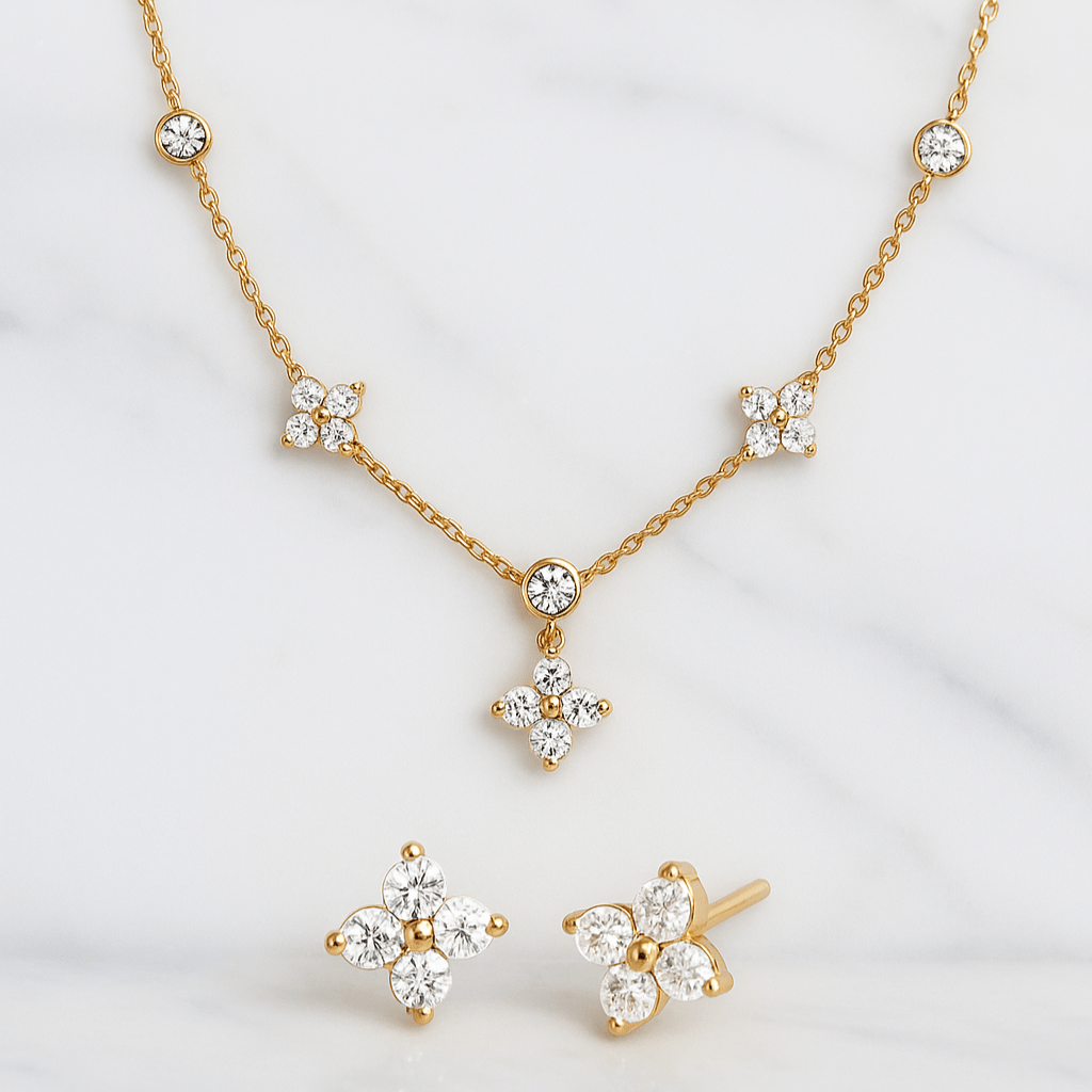 Gold necklace and earrings with diamond-like stones on a white background