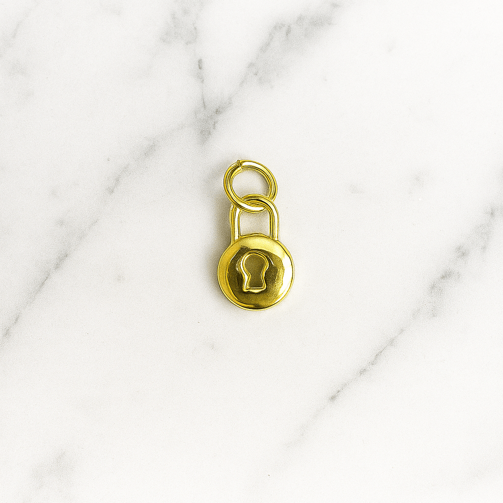 Gold padlock charm on a marble background