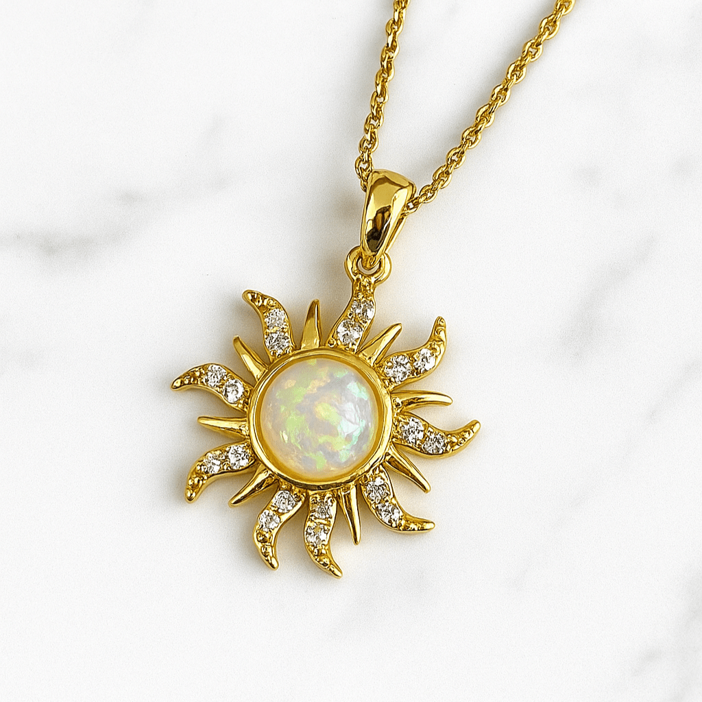 Gold sun-shaped pendant with a central gemstone on a white background