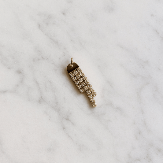 Gold pendant with crystals on a marble surface