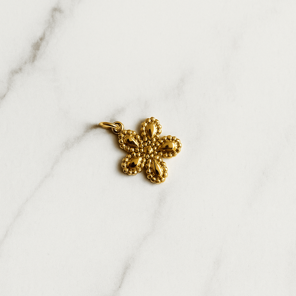 Gold flower-shaped pendant on a marble surface