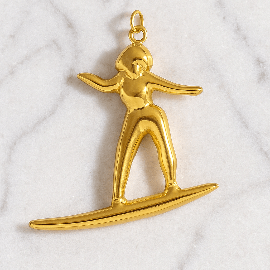 Gold pendant of a person on skis on a marble background