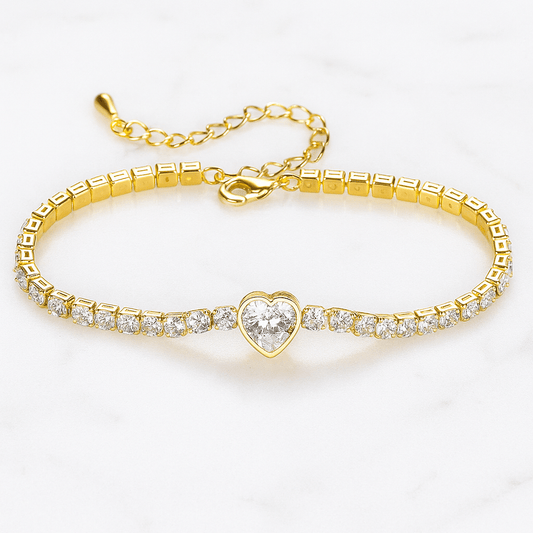 Gold bracelet with a heart-shaped clasp and clear stones on a white background