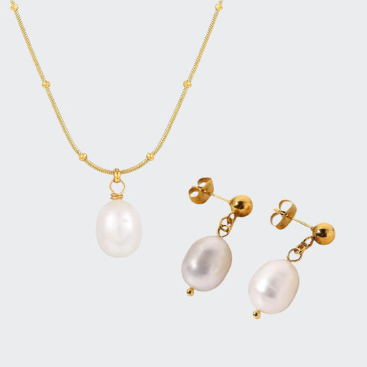A set of jewelry featuring a gold chain necklace with a single white pearl pendant and a pair of gold stud earrings with white pearls.
