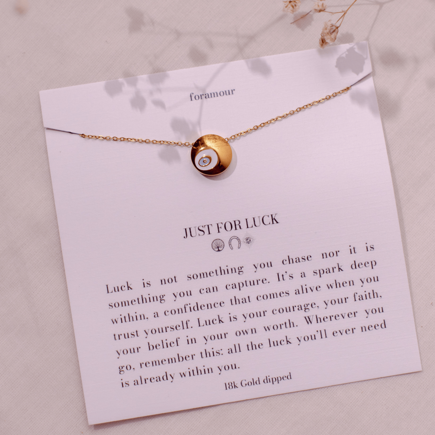 An 18k gold-dipped necklace with a small circular pendant, displayed on a card that reads 'JUST FOR LUCK' along with some motivational text.