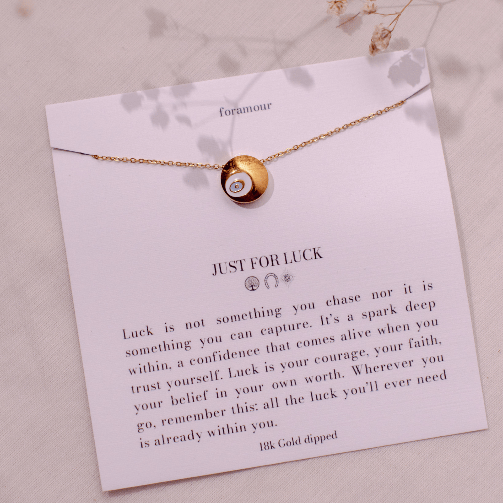 An 18k gold-dipped necklace with a small circular pendant, displayed on a card that reads 'JUST FOR LUCK' along with some motivational text.