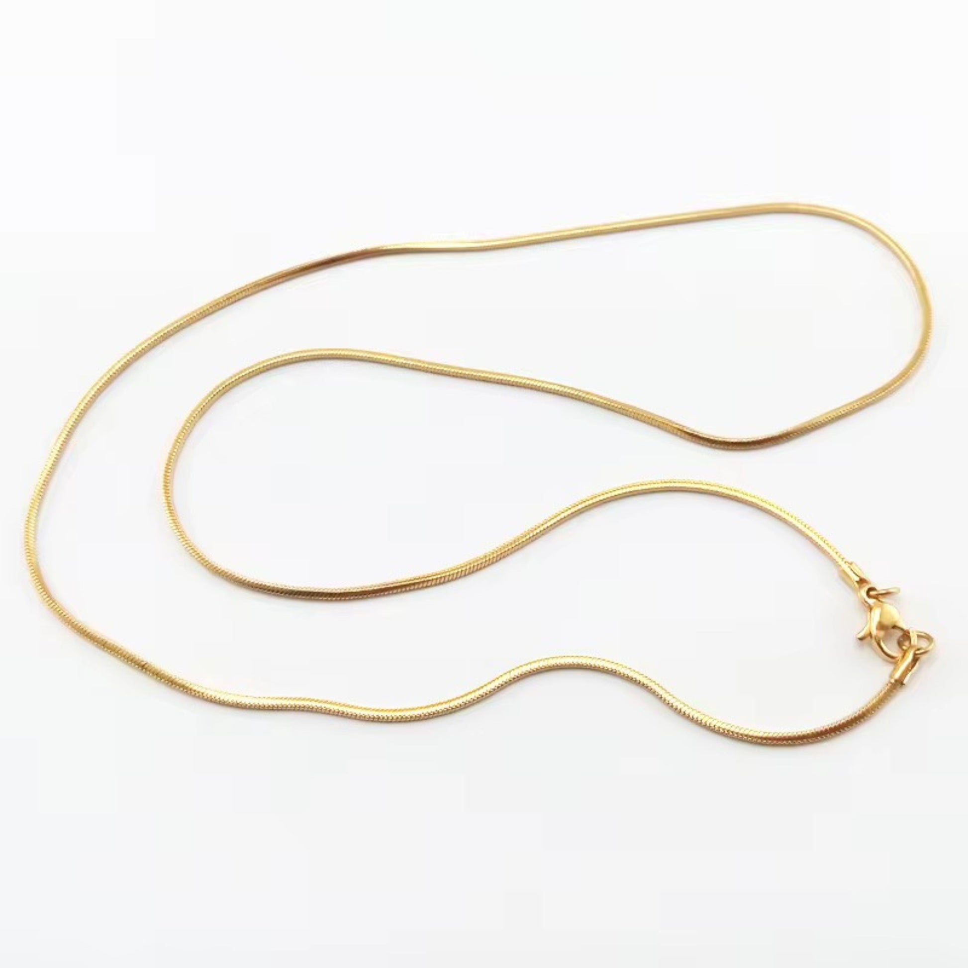 A gold-colored necklace with a simple chain design displayed against a white background.