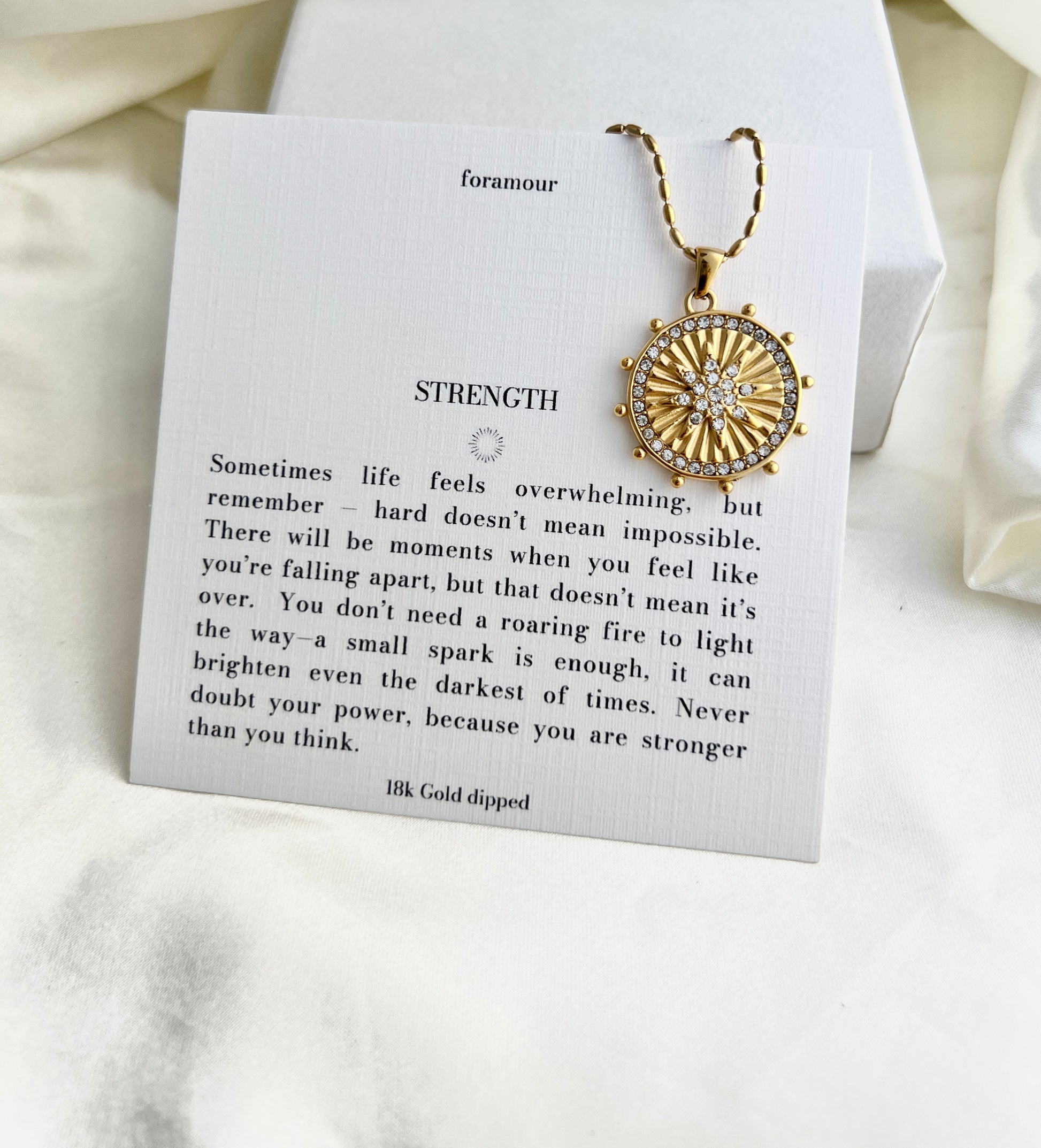 Gold necklace on a card with text and 'foramour' branding