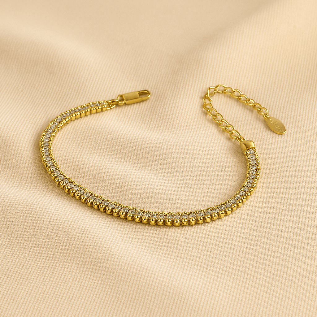Gold bracelet with clear stones on a beige background