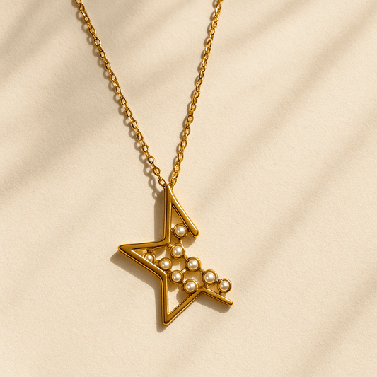 Gold necklace with a star-shaped pendant on a beige background