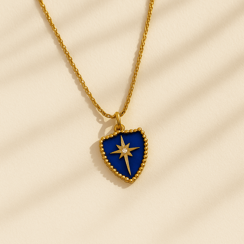 Gold necklace with a blue heart-shaped pendant featuring a star design on a beige background