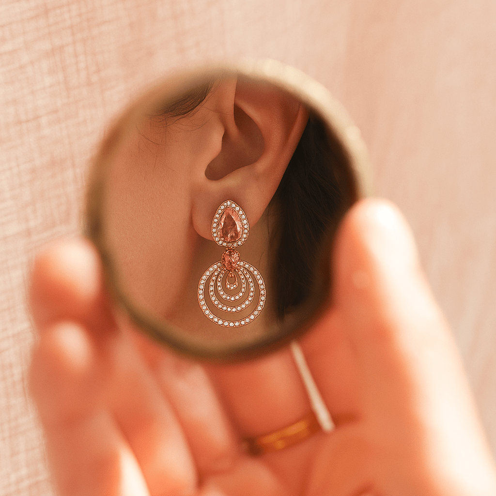 Close-up of an earring being examined in a small mirror held by a hand.