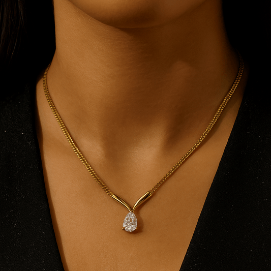 Gold necklace with a diamond pendant on a dark background