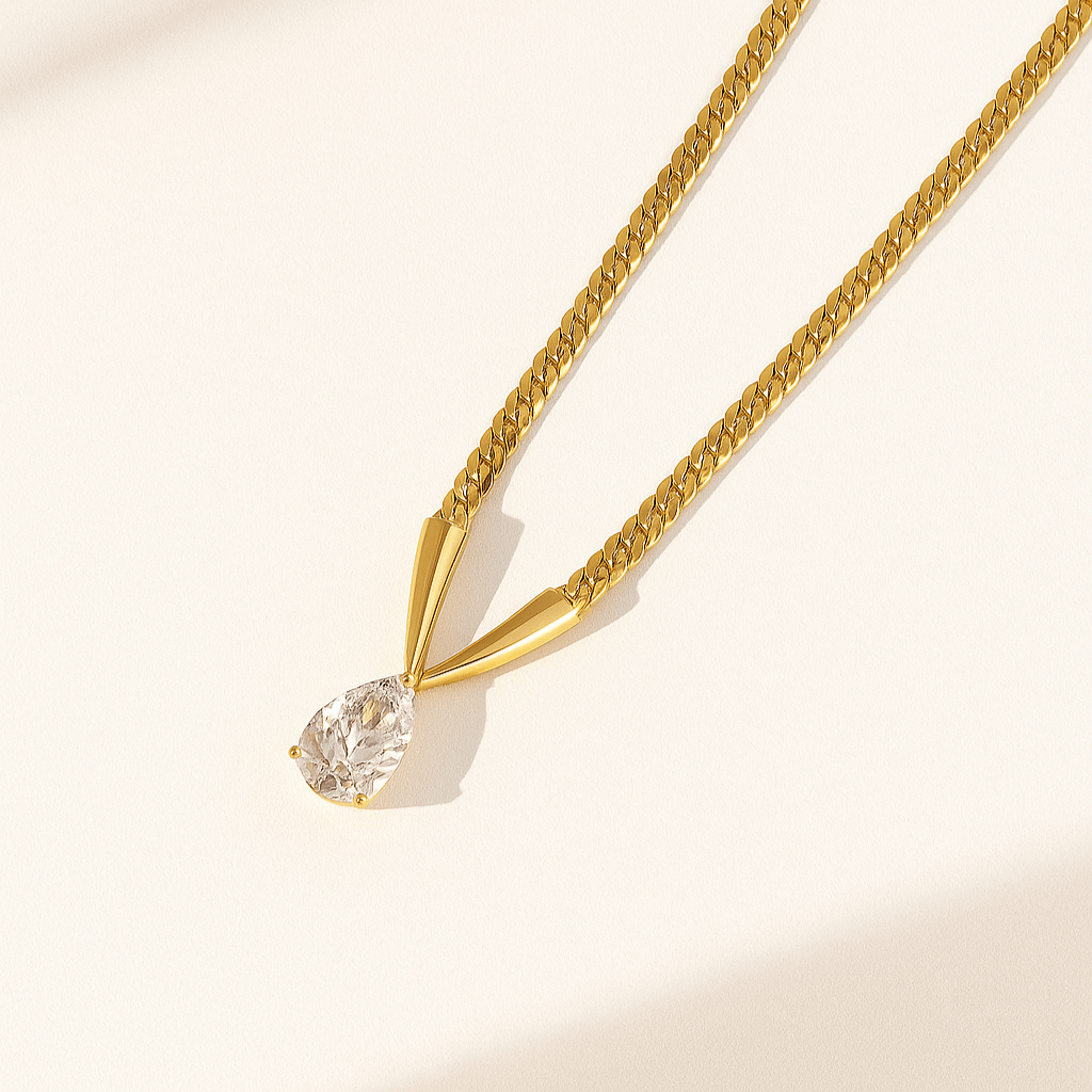 Gold necklace with a diamond pendant on a beige background