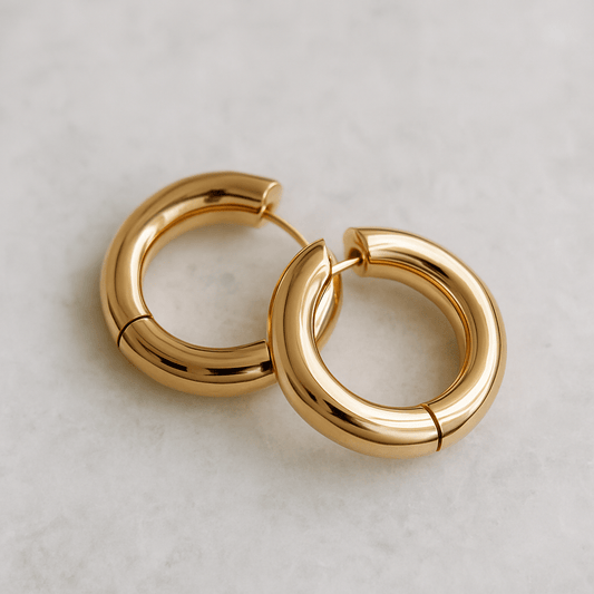 Pair of gold hoop earrings on a light gray background