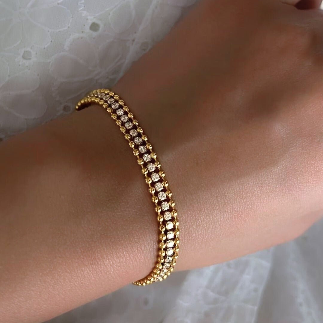 Gold bracelet on a wrist with a blurred background