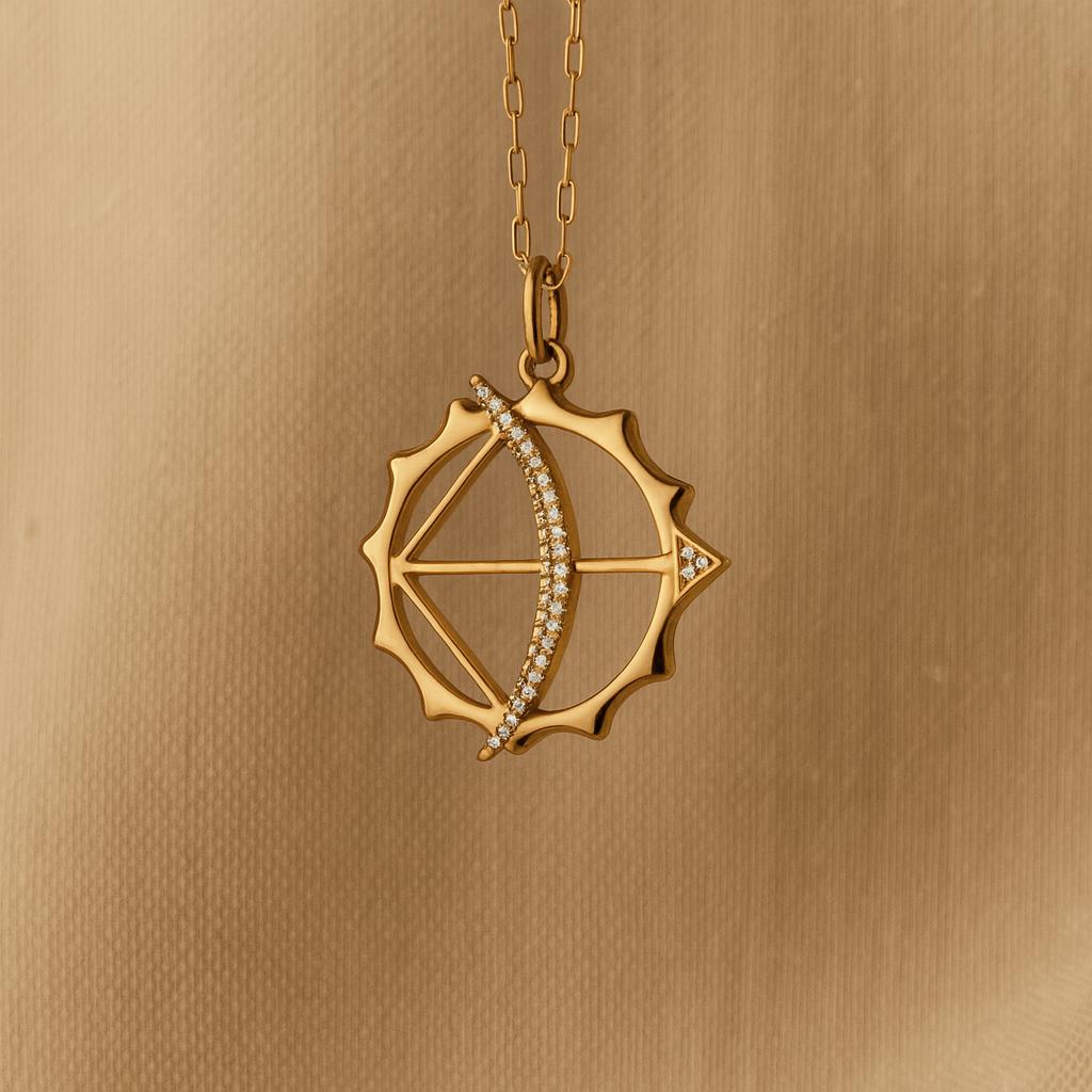 Gold pendant with diamond accents on a gold chain against a gold background