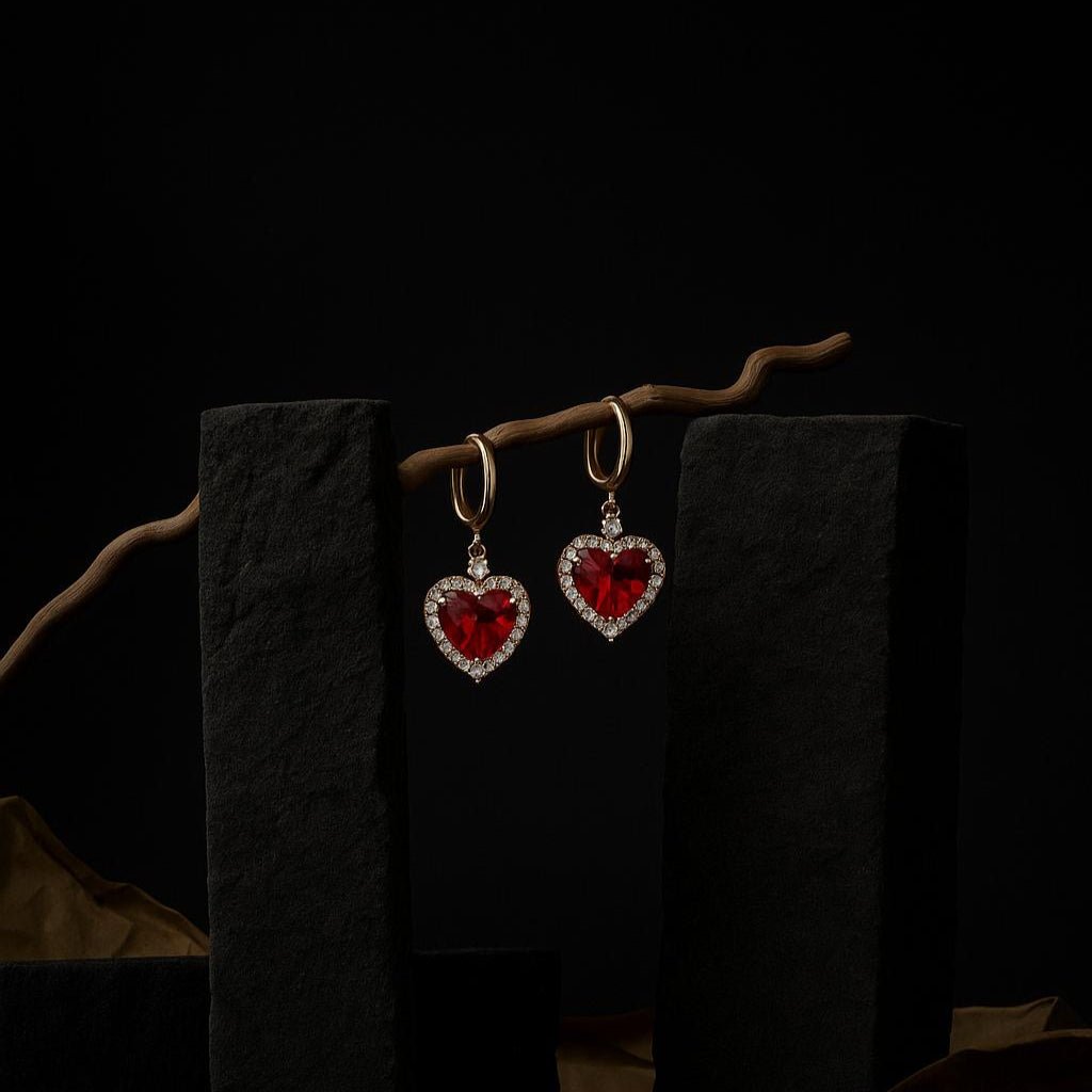 Heart-shaped red gemstone earrings on a dark background
