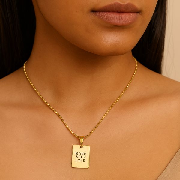 Gold necklace with a pendant on a person's neck