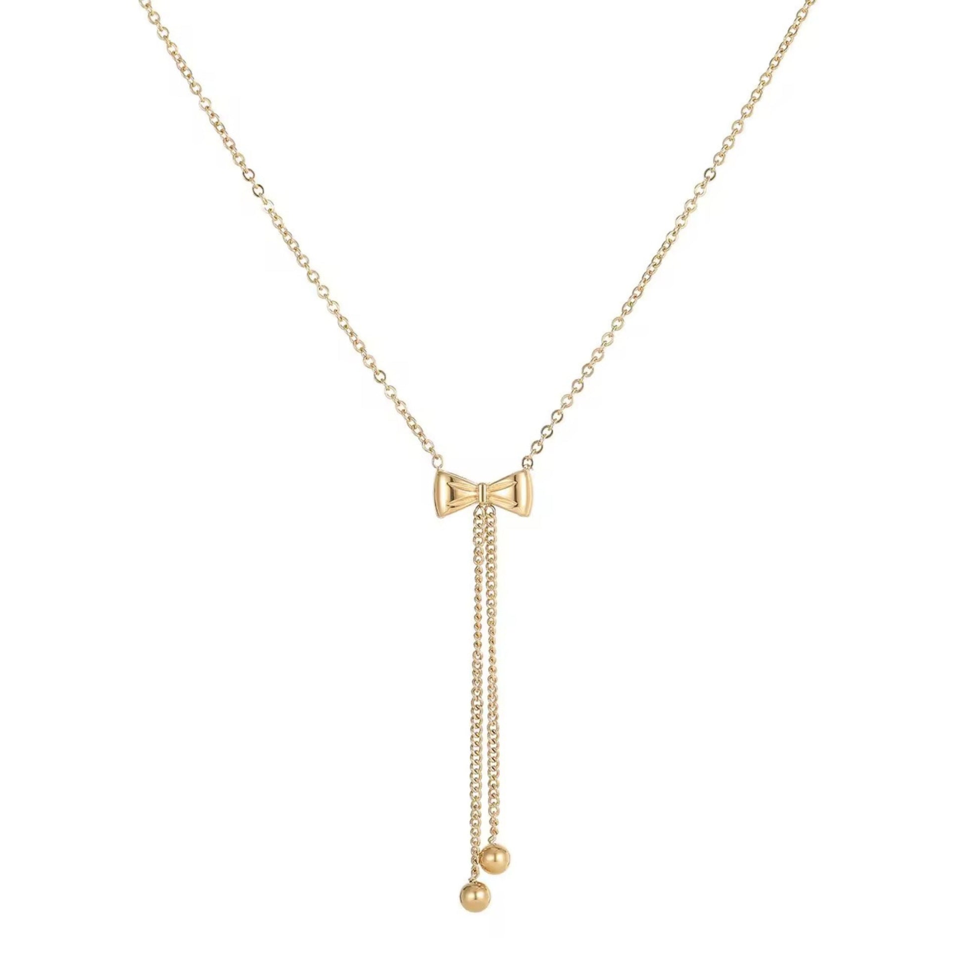 A gold-colored bow necklace with a chain link design and a small spherical pendant at the end.