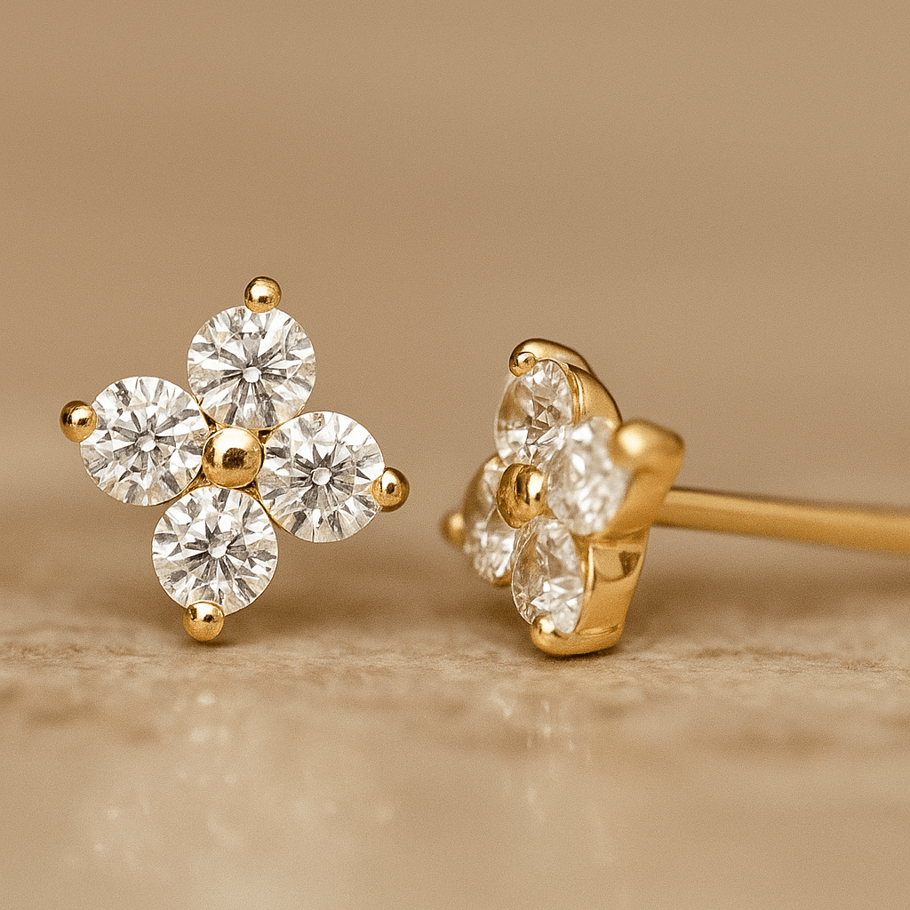 Gold earrings with clear gemstones on a beige background