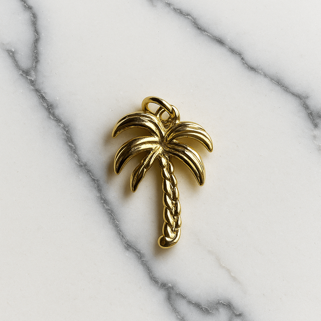 Gold palm tree charm on a marble background