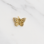 Gold butterfly pendant on a marble surface
