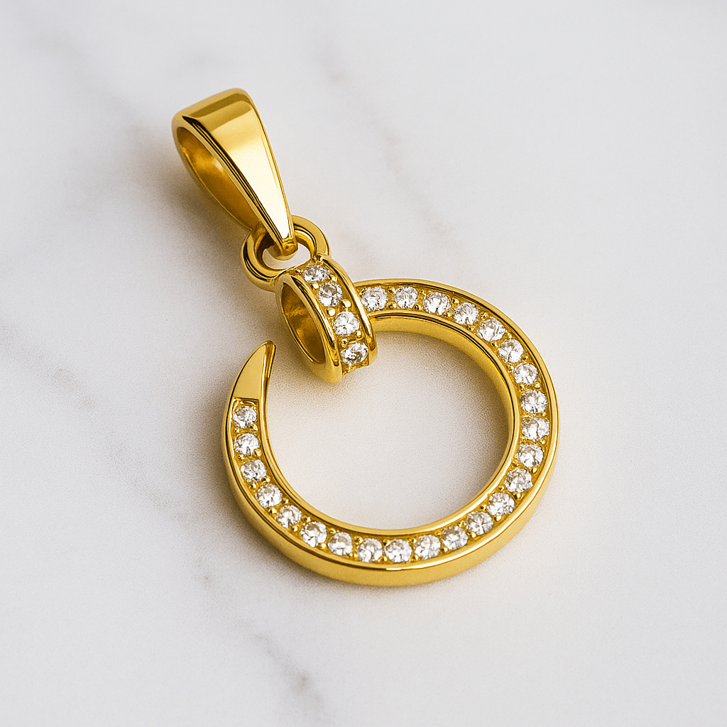 Gold pendant with circular design and embedded stones on a light gray background