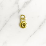 Gold padlock charm on a marble background