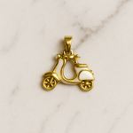 Gold scooter pendant on a marble background