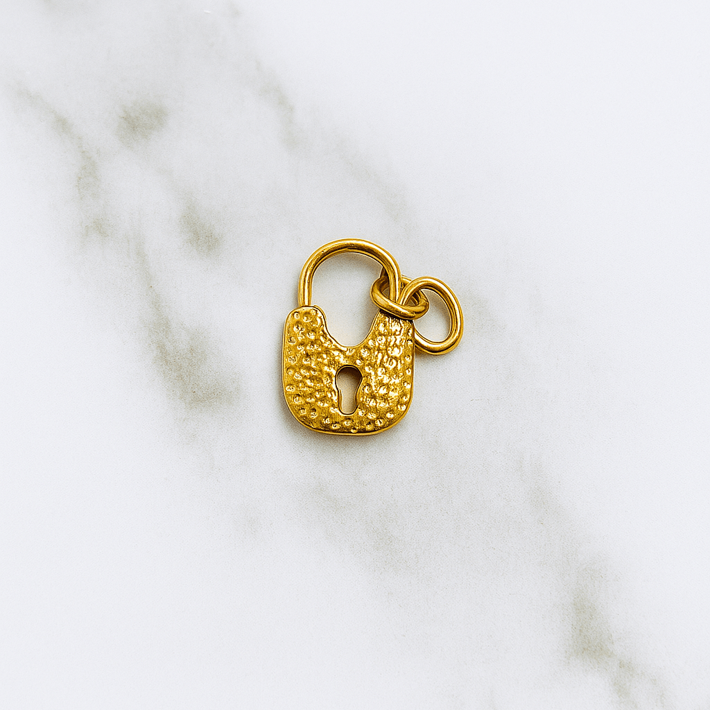Gold padlock charm on a marble background