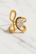 Gold ring with a large diamond on a marble surface