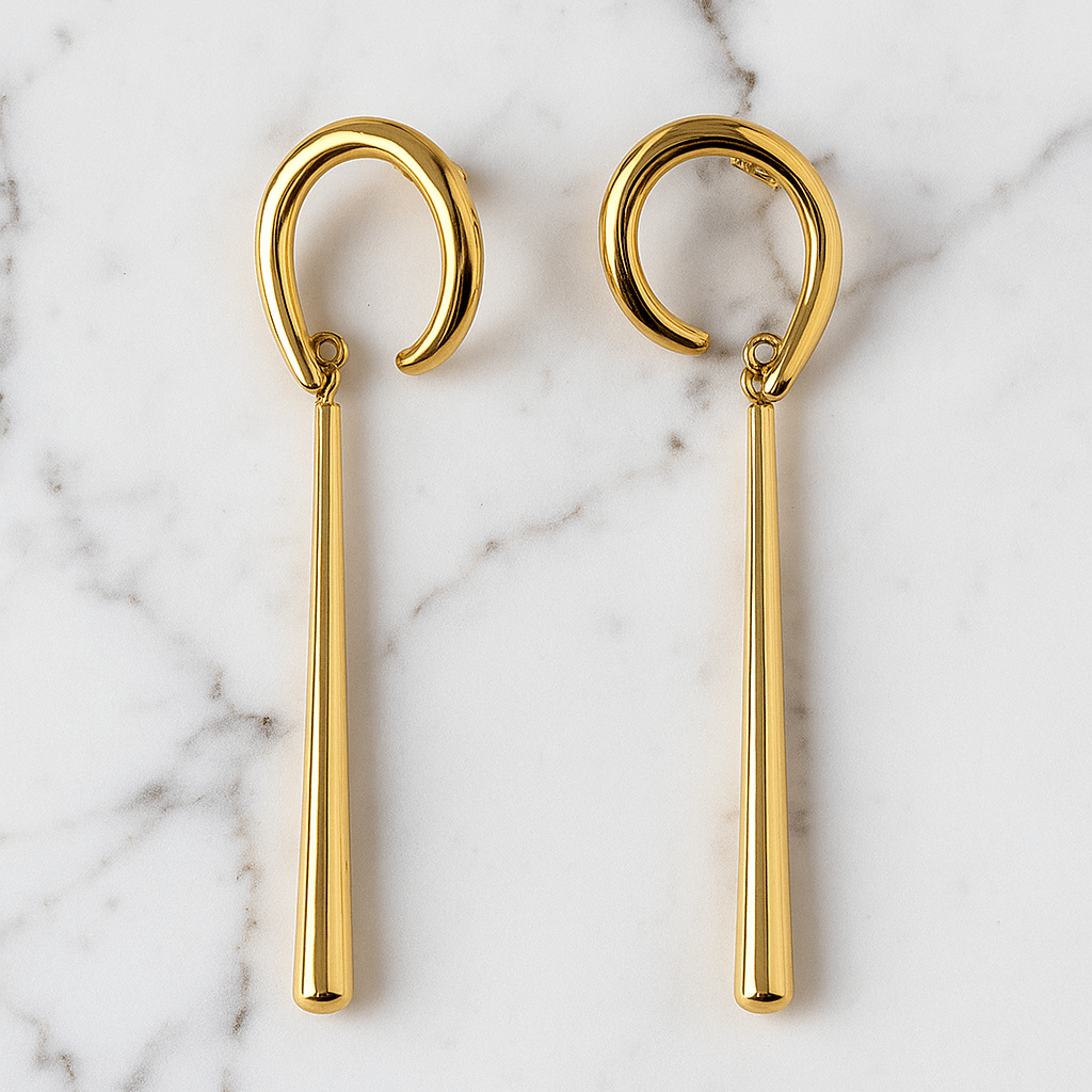 Gold earrings on a marble surface
