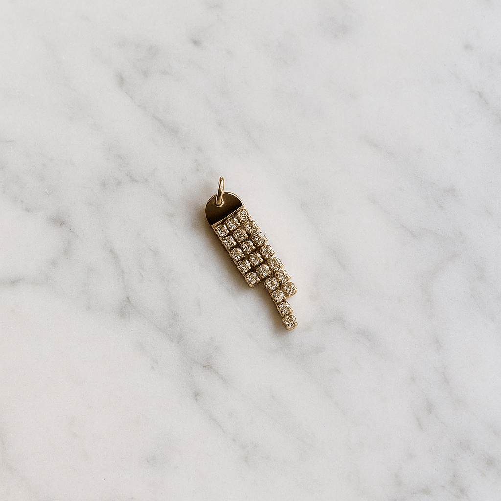 Gold pendant with crystals on a marble surface