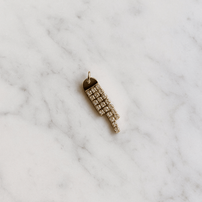 Gold pendant with crystals on a marble surface