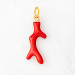 Red coral pendant with gold chain on a white background