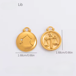 Two gold pendants with Libra zodiac symbol on a white background