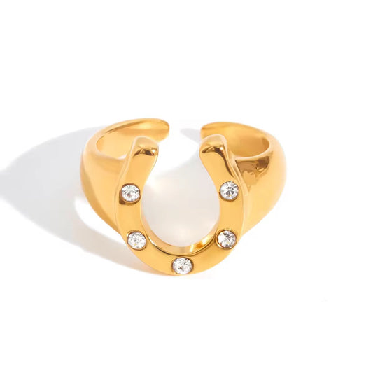 Gold ring with a white pearl and small crystals on a white background