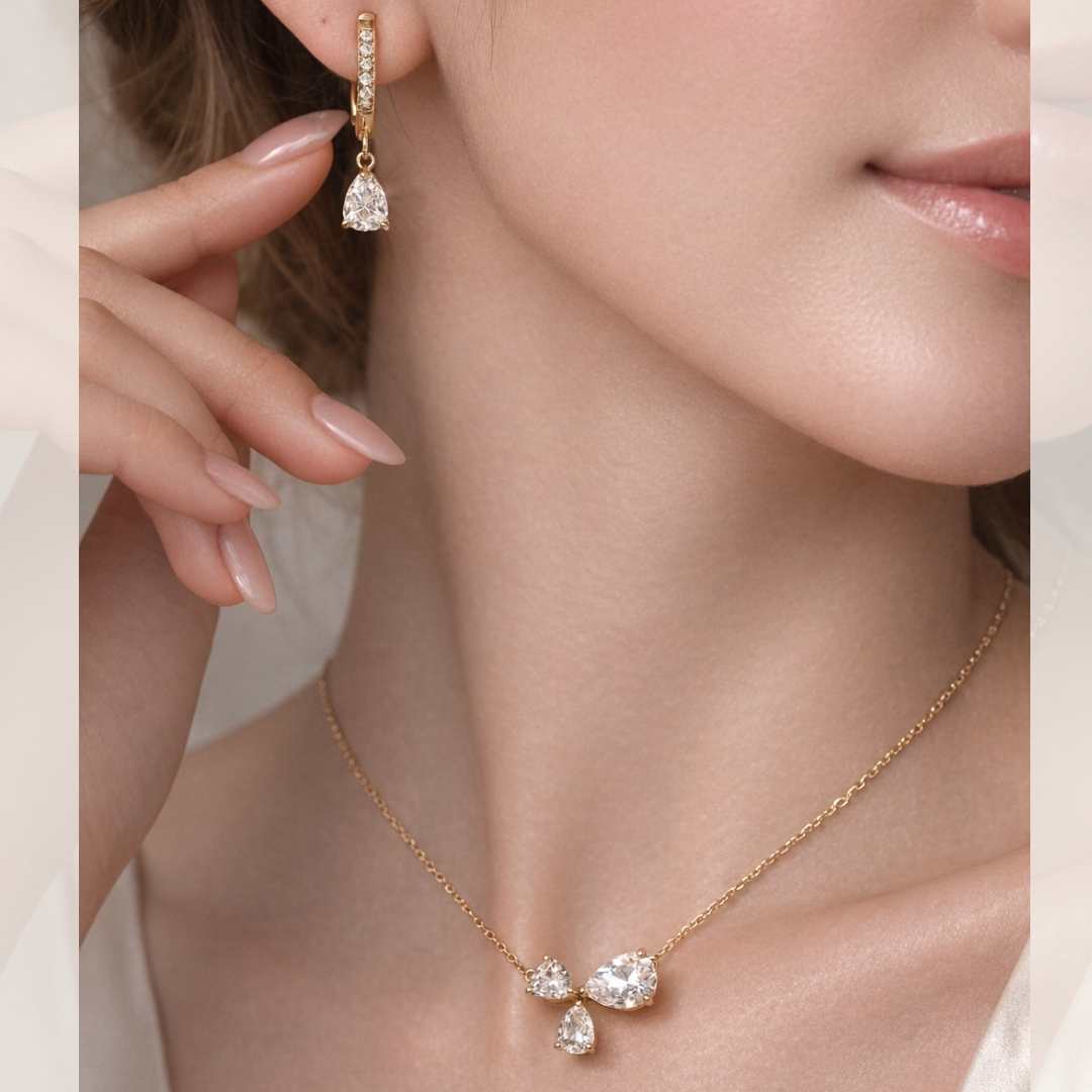 Close-up of a woman wearing a gold necklace and earrings with clear gemstones.