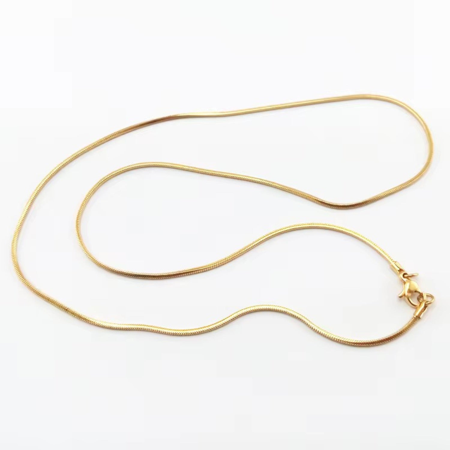A gold-colored necklace with a simple chain design displayed against a white background.