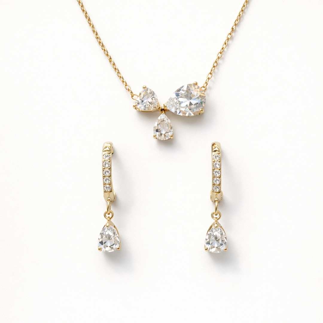 Gold jewelry set with teardrop-shaped crystals on a white background