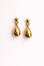 Gold teardrop earrings on a white background