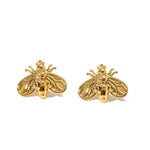 A pair of gold-colored earrings designed in the shape of bees with glossy wings.