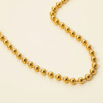 Gold beaded necklace on a white background