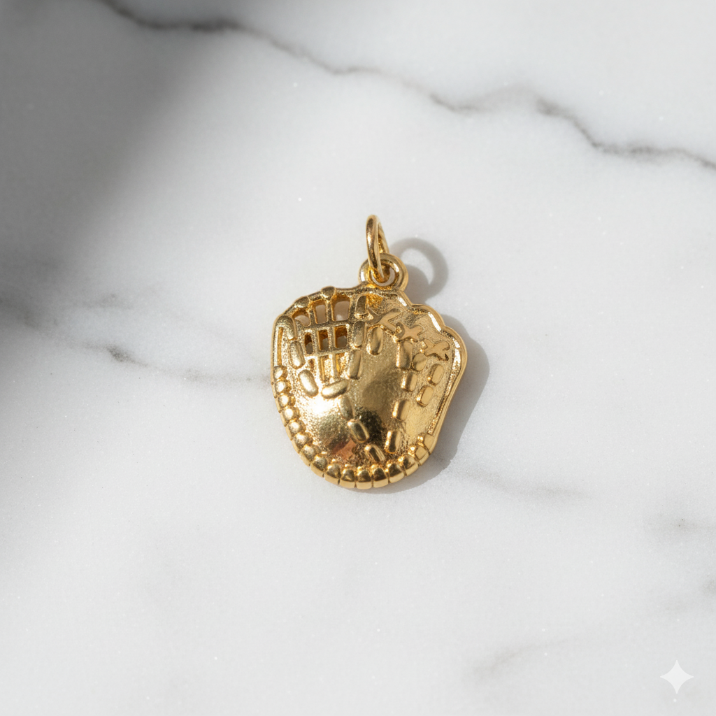 Gold baseball glove charm on a marble surface